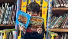 girl reading book in school library