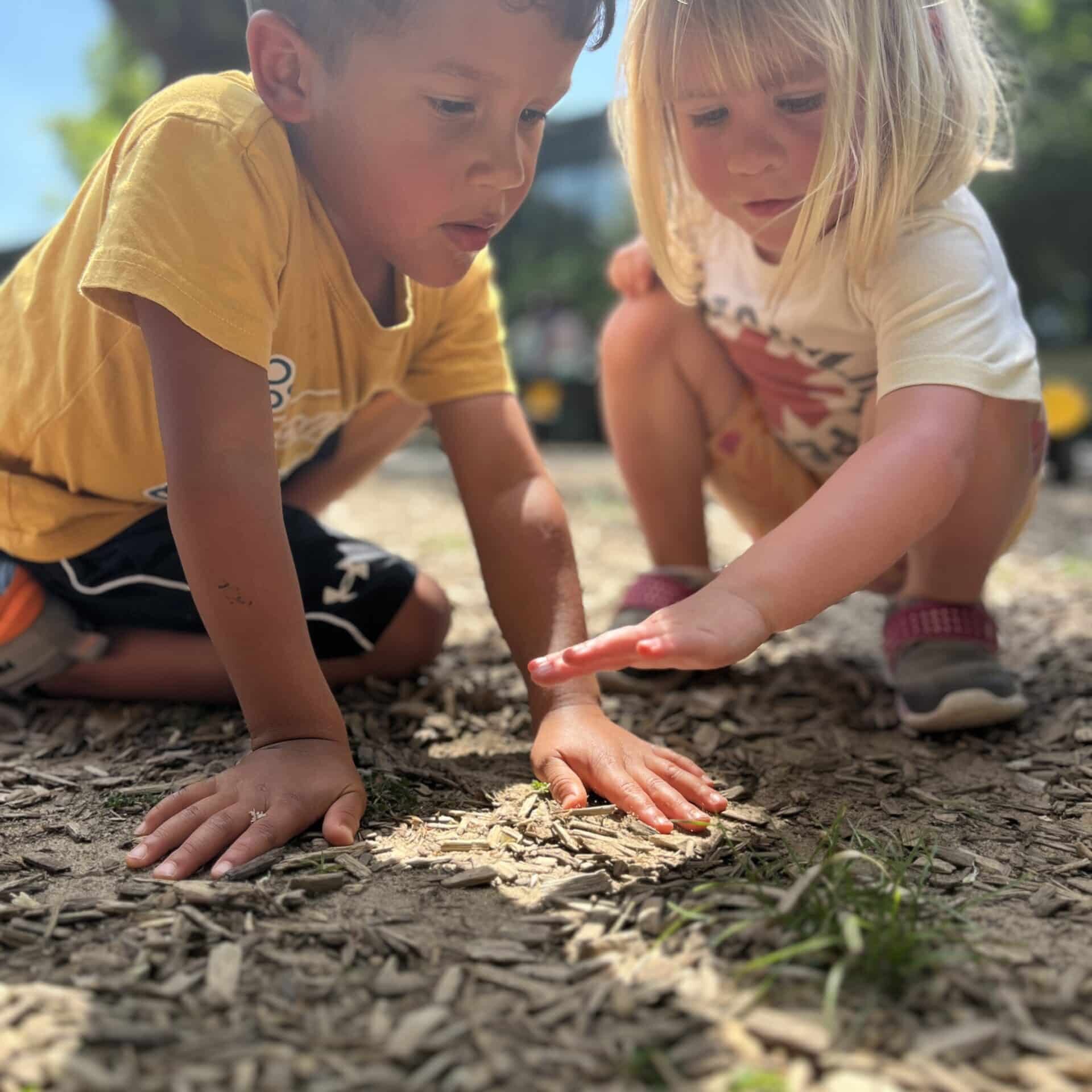 young boy and girl playing in dirt